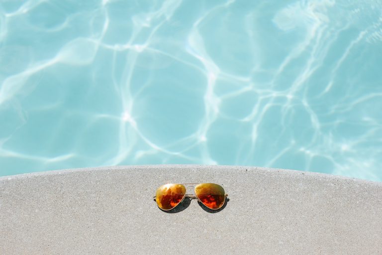 Sunglasses beside the clean pool in a Florida backyard